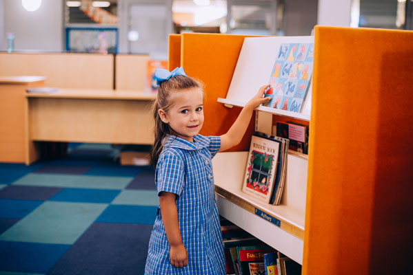 Girl looking at books in St Mary Star of the Sea Catholic Primary School Hurstville library