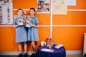 Students holidng up brochures for outreach activities at St Mary Star of the Sea Catholic Primary School Hurstville